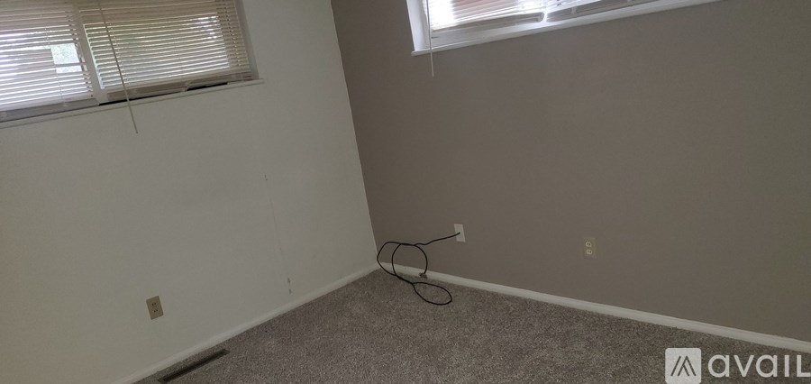 A room with a window and a cable on the floor.