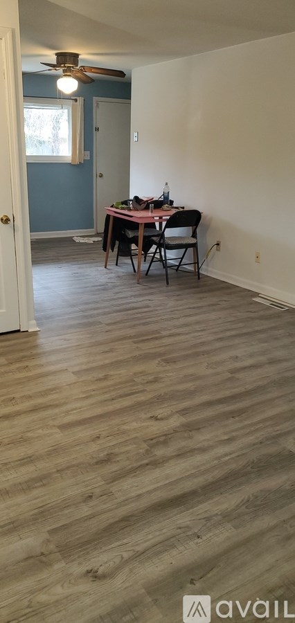A room with a wooden floor and a table with chairs.
