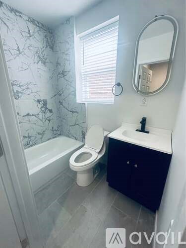 A bathroom with a marble pattern wallpaper and a white toilet.