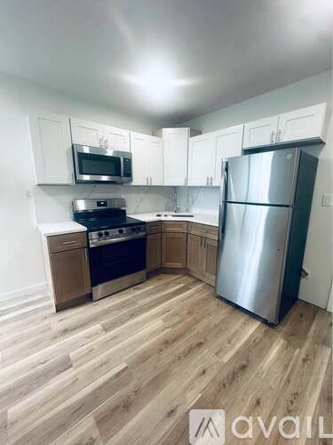 A kitchen with wooden floors and stainless steel appliances.