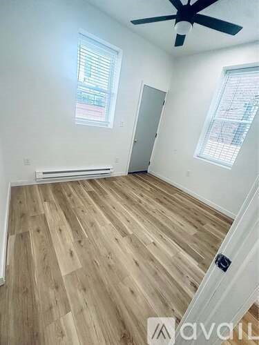 A room with wooden flooring and a ceiling fan.