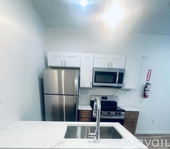 A kitchen with a stainless steel refrigerator and a white countertop.