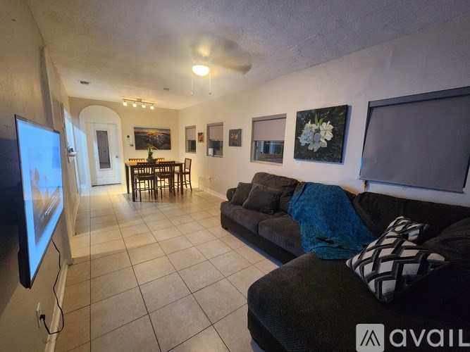 A living room with a couch, television, and pictures on the wall.