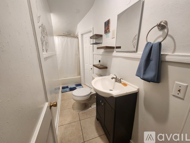 A bathroom with a toilet, sink, and mirror.