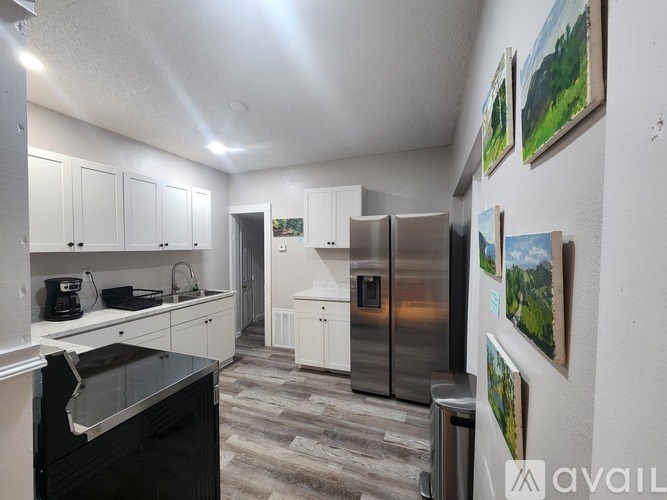 A kitchen with a black dishwasher and a refrigerator.
