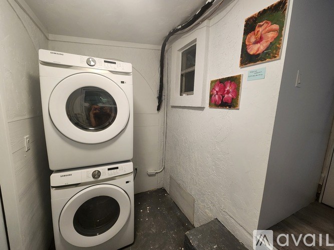 A stack of two white washing machines in a small room.