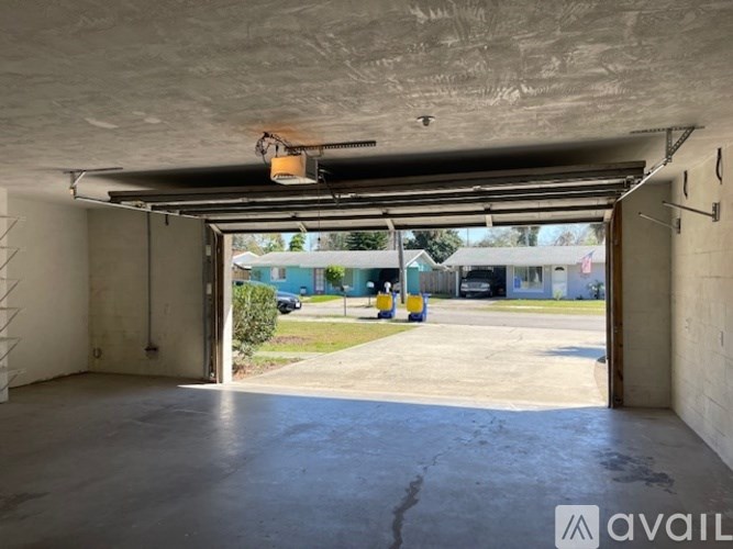 A large empty garage with a view of a parking lot outside.