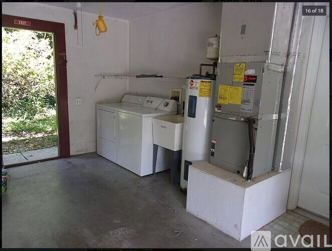 A room with a washing machine and a dryer.