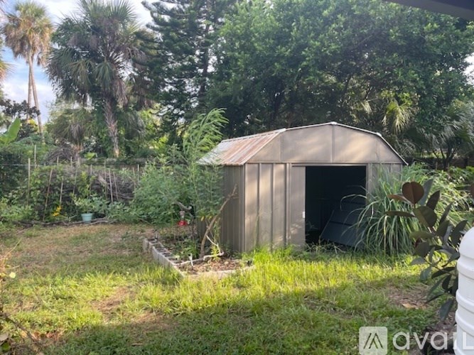 A small shed sits in a lush green garden.