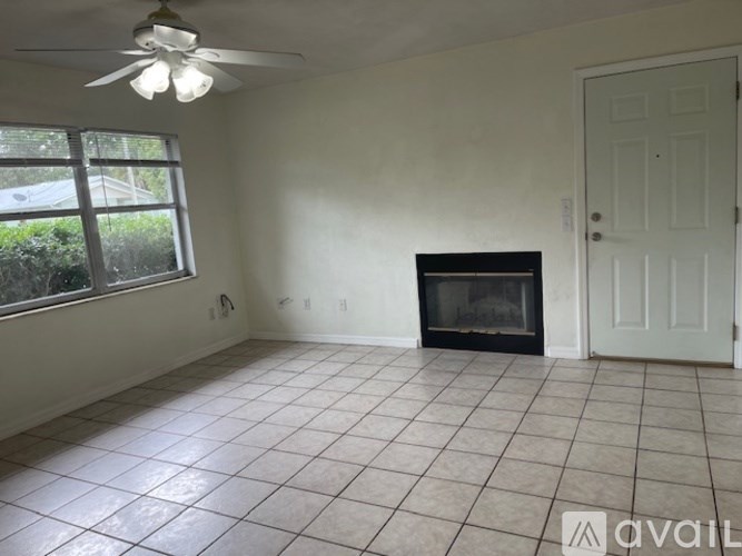 A room with a fireplace and a ceiling fan.