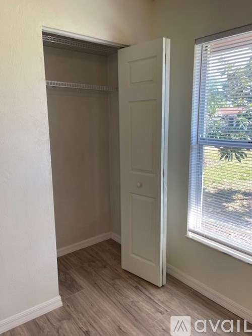 A room with a white door and a window with blinds.
