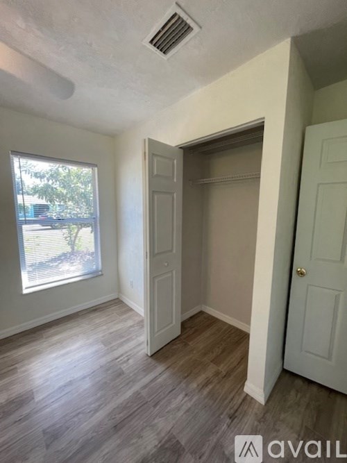 A room with a window and a door is available for rent.