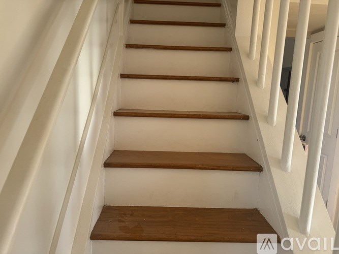 A set of stairs with white railings and wooden steps.