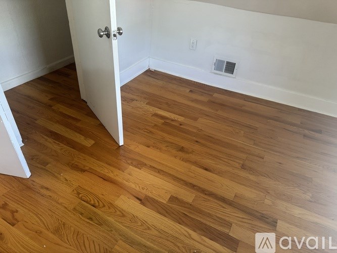 A room with a wooden floor and a white door.