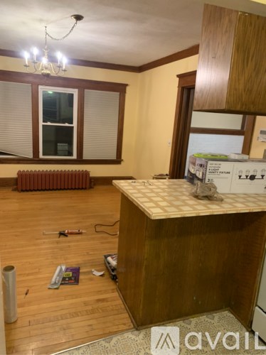 A room with a wooden cabinet and a window with blinds.