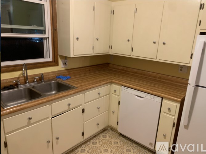 A kitchen with wooden cabinets and a white fridge.