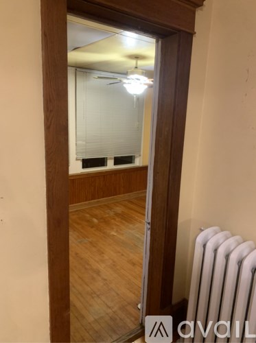 A room with a white radiator and wooden flooring.