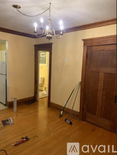 A room with a chandelier and a wooden door.