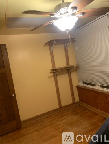 A room with wooden floors and a ceiling fan.