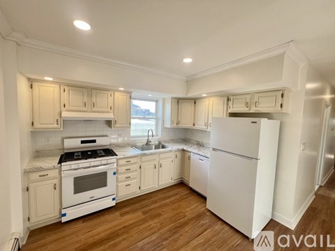 A kitchen with white appliances and cabinets.