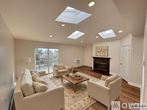 A living room with a couch, chairs, and a fireplace.