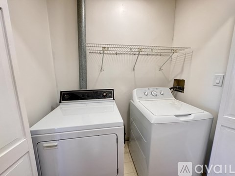 A white washing machine and dryer in a small laundry room.