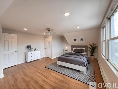 A bedroom with a bed, dresser, and ceiling fan.