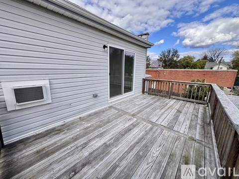 A deck with a sliding glass door and a small window.