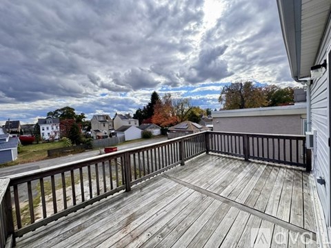 A deck with a railing overlooking a residential area.