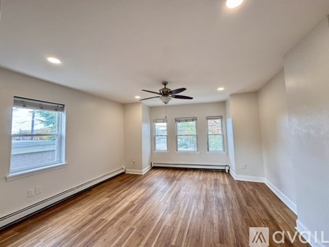 A room with wooden flooring and a ceiling fan.
