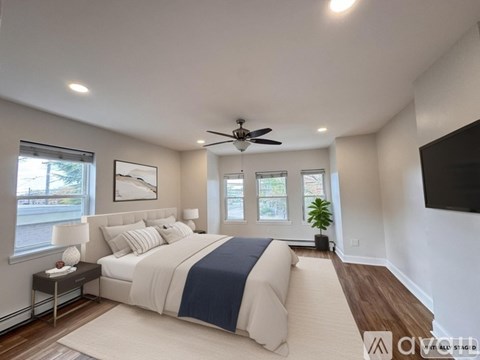 A bedroom with a large bed and a ceiling fan.