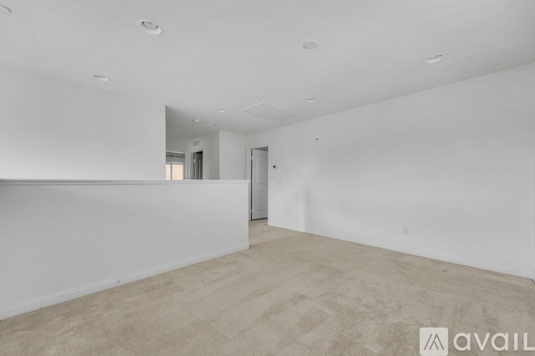 A spacious room with a carpeted floor and a mirror on the wall.