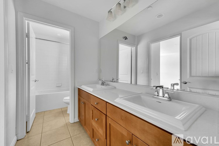 A bathroom with a white sink, mirror, and wooden cabinets.