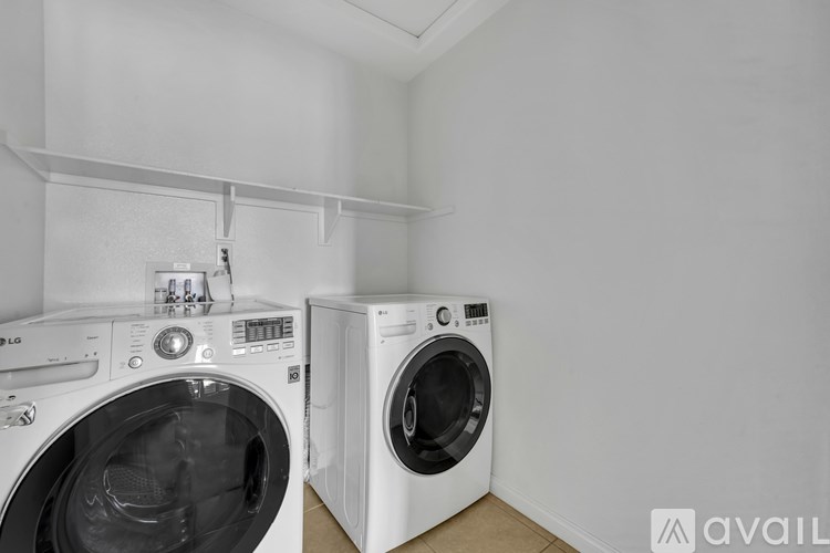 Two white front loading washing machines in a laundry room.