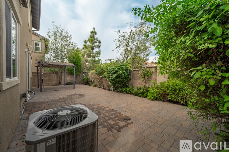 A patio with a fan and a brick wall.