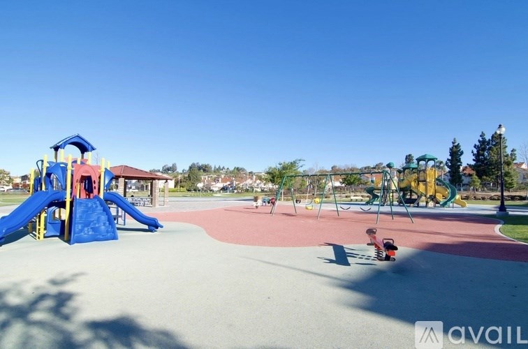 A playground with a blue slide and a red and yellow structure.
