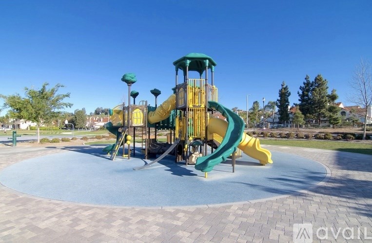A playground with a green and yellow slide.
