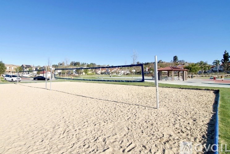A beach volleyball court with a net and sand.