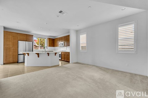 A spacious kitchen with wooden cabinets and white appliances.