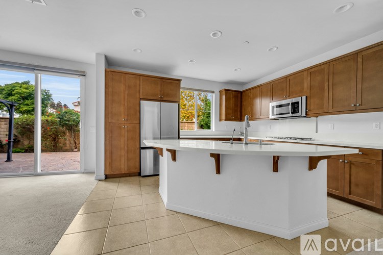 A kitchen with white countertops and wooden cabinets.