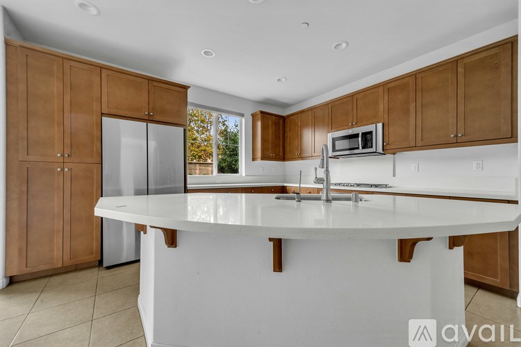 A kitchen with wooden cabinets and a white island.