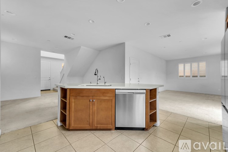 A kitchen with a white countertop and a wooden cabinet.