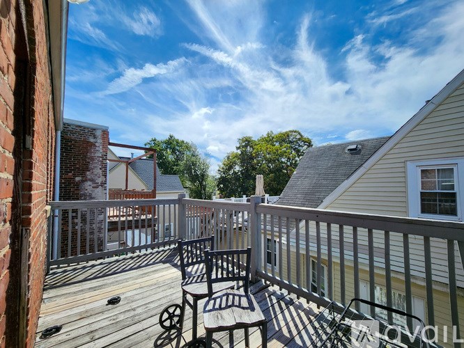 A wooden deck with a table and chairs overlooking a residential area.