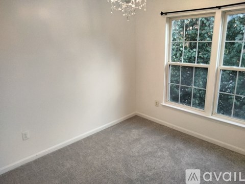 A room with a window and a chandelier.