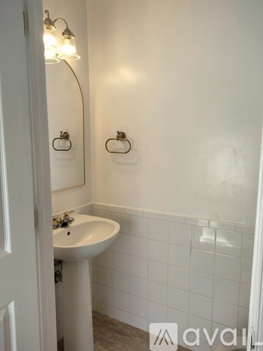 A white sink in a bathroom with a white door.