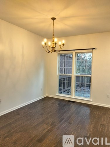 A room with a chandelier and a window overlooking a construction site.