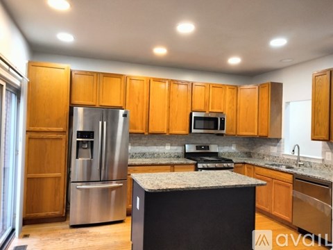 A kitchen with wooden cabinets and a stainless steel refrigerator.