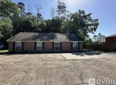 A house with a grey roof and a driveway in front of it.