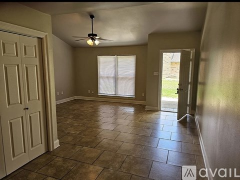 A room with a ceiling fan and tile flooring.