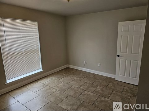 A room with a tiled floor and a door.